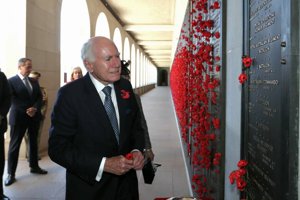 Paying tribute: Former prime minister John Howard lays a poppy at the Afghanistan Roll of Honour during the Remembrance Day ceremony at the Australian War Memorial. Photo: Alex Ellinghausen