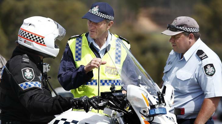 Senior Constable Bret Marro, left, from the Traffic Operations chats with Sergeant Dick Dauth and Senior Constable Frazer Woods of the Collision Investigation and Reconstruction Team following stopping distances tests at the Australian Federal Police Training Facility. Photo: Jeffrey Chan