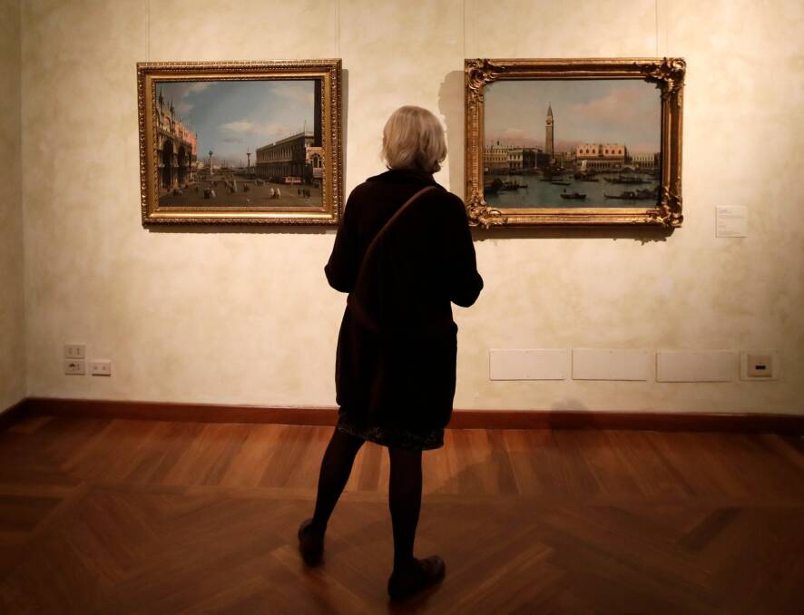 A woman looks at the oil on canvas paintings "The Molo from the Bacino di San Marco" right, and "The Piazza San Marco and Piazzetta looking South", by 18th century Venetian master Giovanni Antonio Canal, known as Canaletto, displayed during the press preview of the exhibition "Canaletto 1697 - 1768", at the Braschi Palace, in Rome. Photo: AP