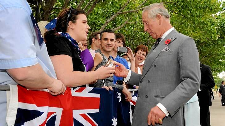 The Prince of Wales receives a packet of Tim Tams from a Allyson Richards. Photo: Colleen Petch