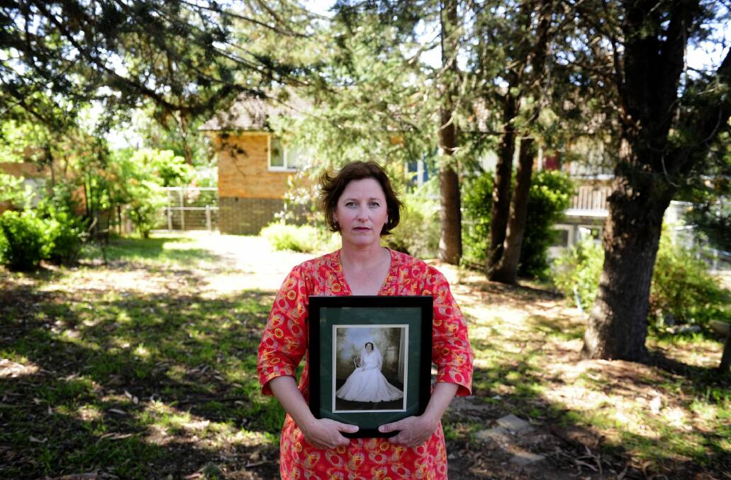 Robyn Elliott with a photo of her mother Geraldine Elliott, outside her former home in Hughes. Photo: Melissa Adams