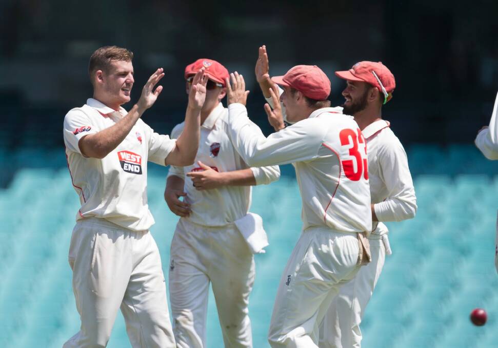 Nick Winter (left) celebrates after taking the wicket of Peter Nevill at the SCG. Photo: Craig Golding
