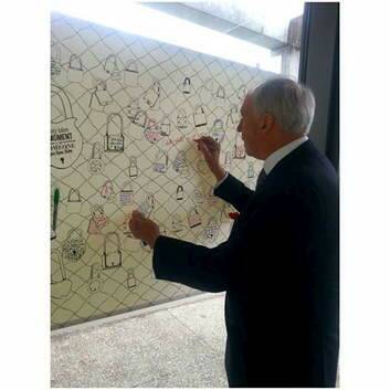 Former prime minister Paul Keating signing a message board for Australian troops organised by Lifeline.