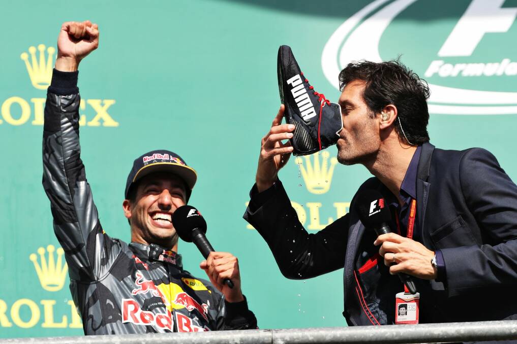 Mark Webber drinks champagne from the boot of Daniel Ricciardo of Australia and Red Bull Racing on the podium during the Formula One Grand Prix of Belgium. Photo: Mark Thompson
