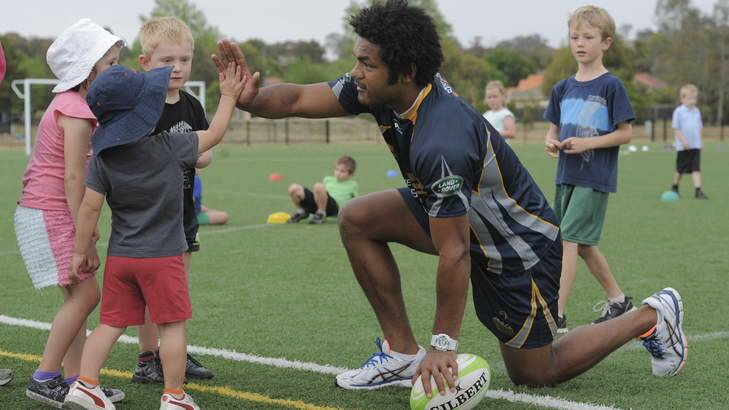 Brumbies winger Henry Speight at a junior rugby development event at Gold Creek Primary School on Friday. Photo: Graham Tidy