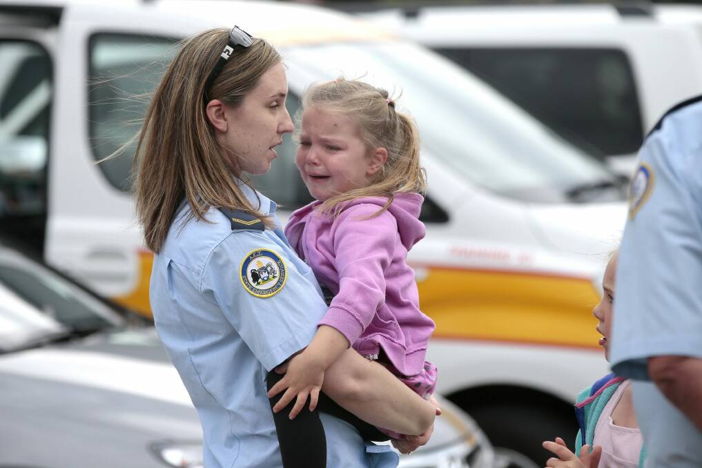 ACT SES volunteer Elisabeth Rundle comforts her daughter Carly, 4, before leaving to help clean up storm damage.  Photo: Jeffrey Chan