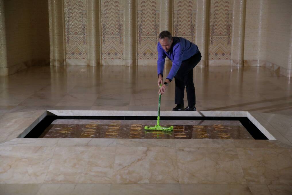 Opposition Leader Bill Shorten cleans dust from the Tomb of the Unknown Soldier. Photo: Andrew Meares