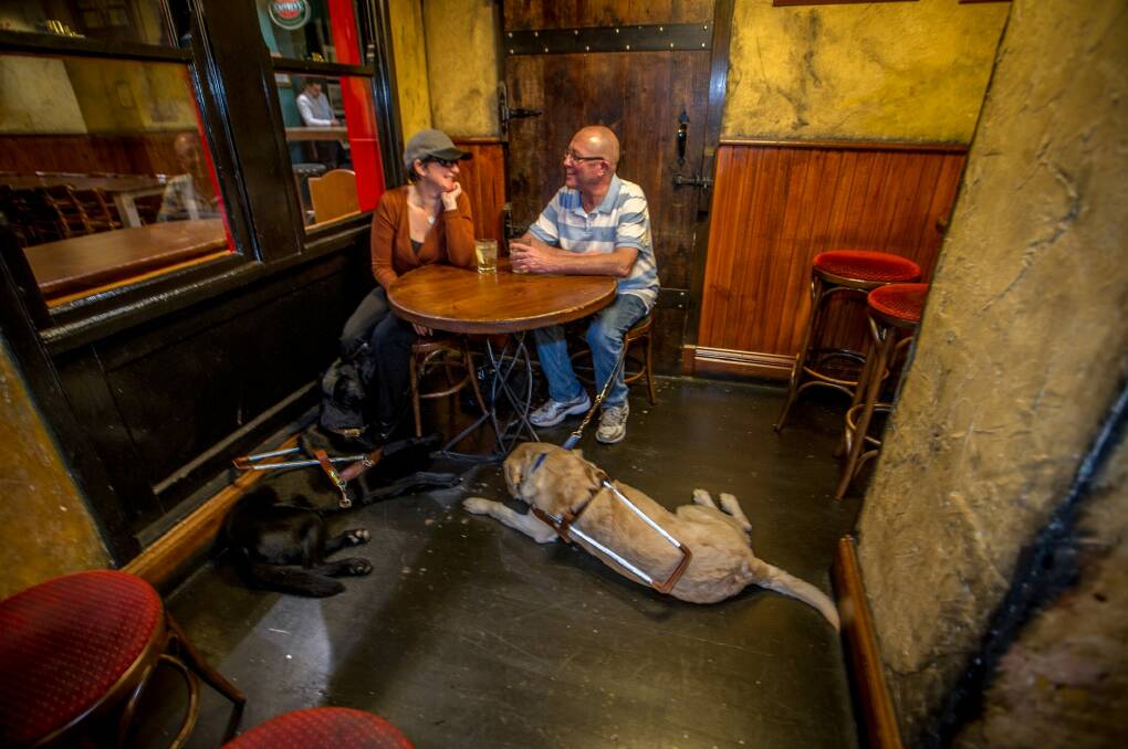 Guide dog handler Jo Weir and fiancee Justin Simpson with their guide dogs Wiley (black) and Yarrin (gold) enjoying King O'Malley's Pub in Civic.  Photo: Karleen Minney