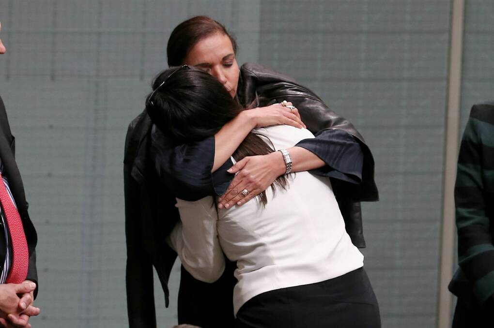 Anne Aly embraces Labor MP Emma Husar after Husar spoke about her experience with family violence. Photo: Alex Ellinghausen