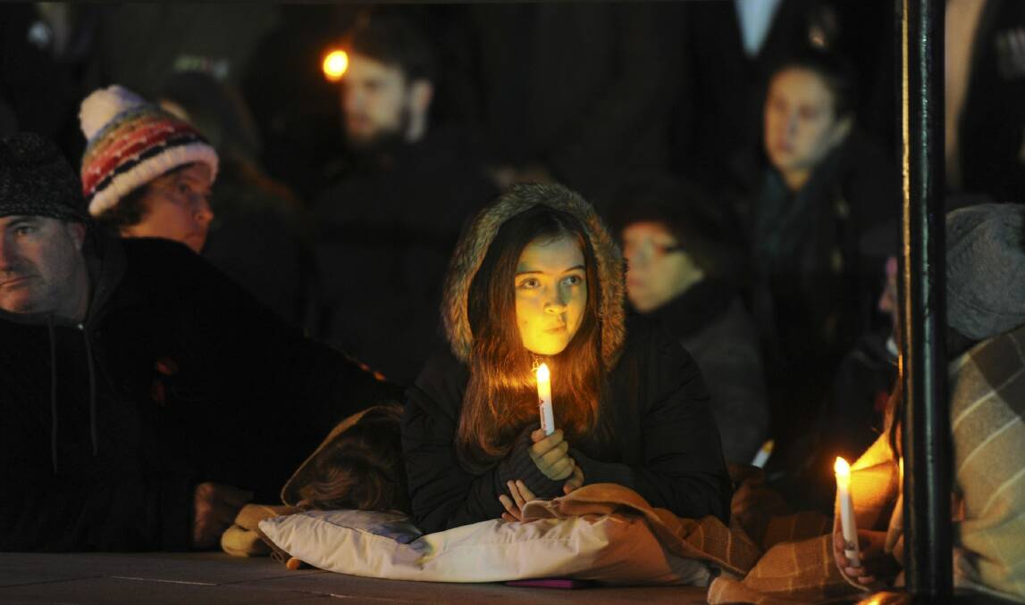 A girl holds a candle at the Anzac Day dawn service. Photo: Graham Tidy