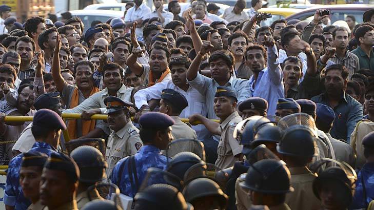 In mourning &#8230; police officers stand guard as a crowd gathers near the home of the right-wing politician Bal Thackeray. Photo: Reuters