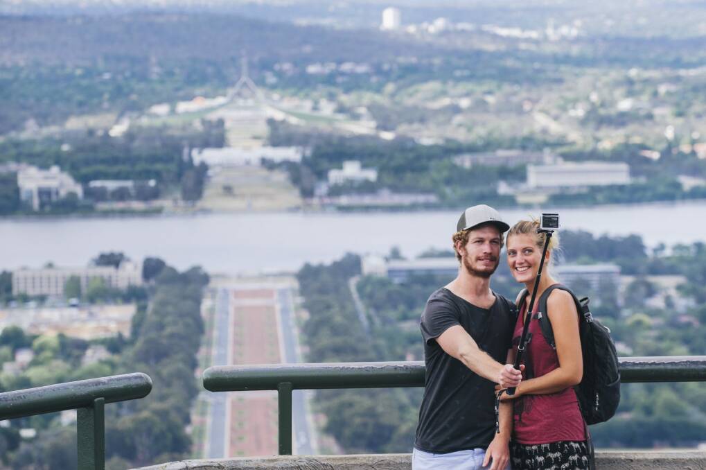 Tourists George Wootten and Hannah Barrington take a selfie with the view from Mt Ainslie Photo: Rohan Thomson