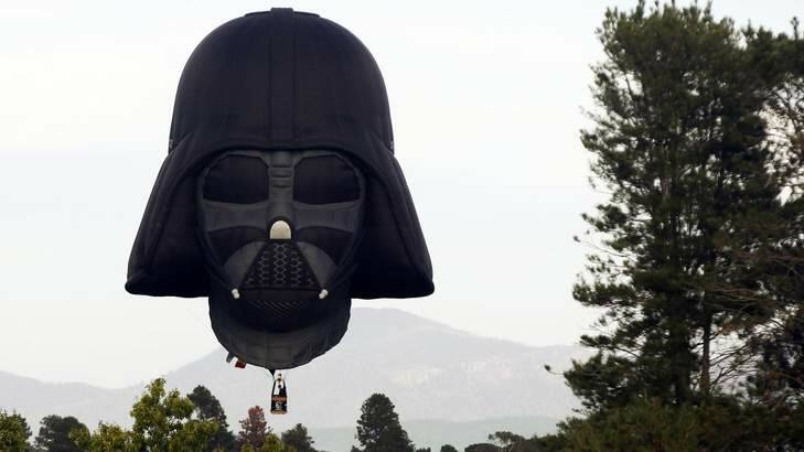 A hot air balloon shaped like Darth Vader's head lands after a sunrise flight in Canberra. Photo: Reuters