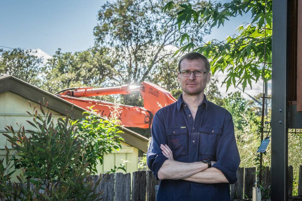 Brendan Pippen, in the backyard of his Duffy home, succeeded in persuading the government to demolish his neighbour's garage, in the background, which was used to store asbestos from the neighbour's Fluffy house. Photo: Karleen Minney