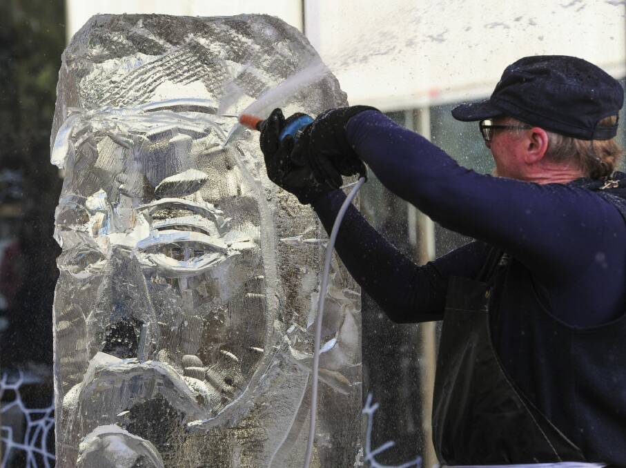 Glenn Smith at work on his ice sculpture of Sir Henry Parkes in Canberra on Sunday. Photo: Graham Tidy