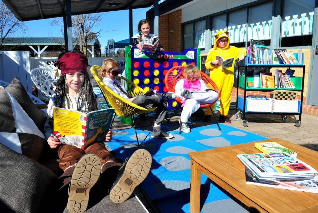 Reading in the new outdoor learning space at Bonython Primary school are, from left, Nek Stergiou,5 of Bonython, Nathanael Barons,10 of Isabella Plains, Ariadne Stergiou,11 of Bonython, Montana Gum,8 of Macarthur, and Cooper Gum,9 of Macarthur.  Photo: Melissa Adams
