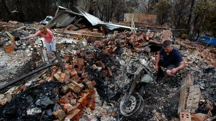 Paul and Karen Bousfield pick through the rubble of their home in Buena Vista Rd, Winmalee. Photo: Dallas Kilponen