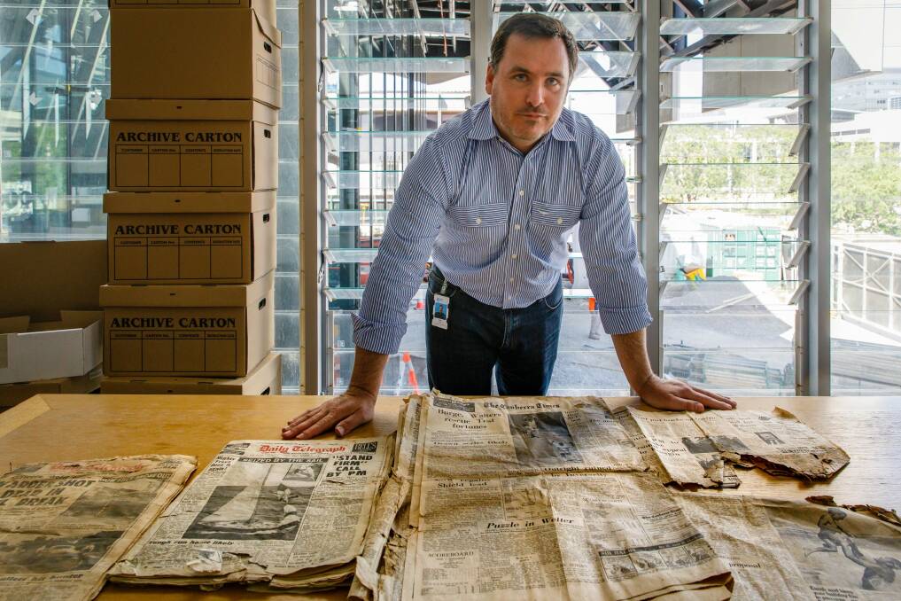 Contract manager Sean Egan with an old copy of The Canberra Times found during excavations for the courts building project. Photo: Sitthixay Ditthavong