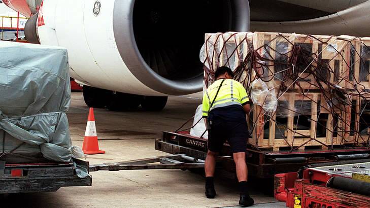 A worker loads airfreight in Sydney. Photo: Rob Homer