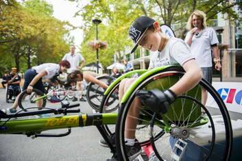 Tom Curtis, 9, races in a wheelchair race against Australian Paralympian, Madison de Rozario at the race on rollers on City Walk to kick off the Summer Down Under Series. Photo: Rohan Thomson