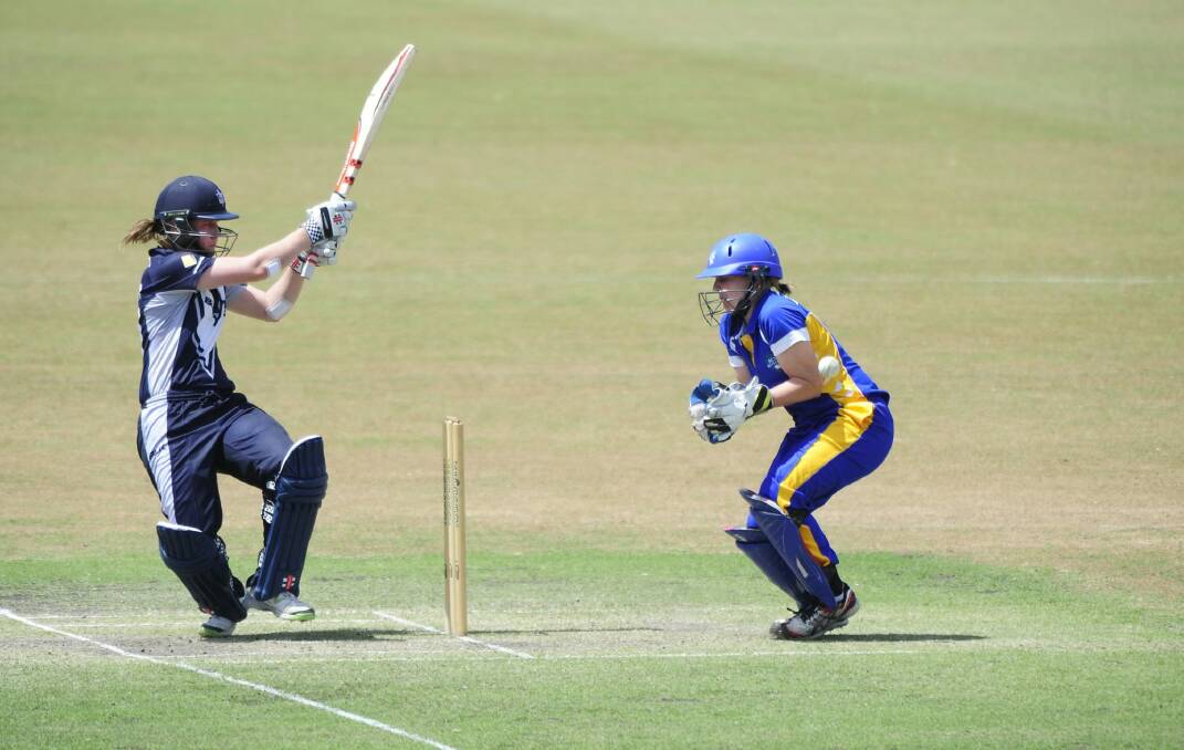 Victoria Spirit batter Meg Lanning plays a shot with ACT Meteors 'keeper Laura Wright watching on in Sunday's women's Twenty20 match at Manuka Oval. Photo: Melissa Adams