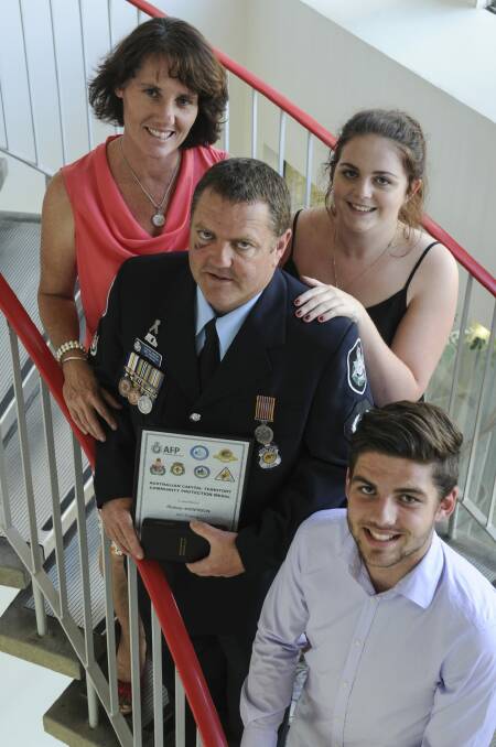 Station Sergeant Rodney Anderson was one of five recipients of the ACT Community Protection Medal. He is pictured with his wife, Donna and children, Ashlea, 20 and Will, 17.   Photo: Graham Tidy