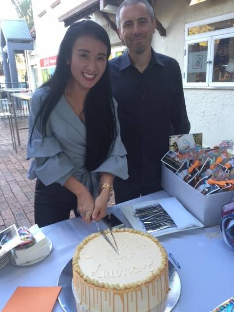 Orange Sky Laundry Canberra service manager Noreen Vu and volunteer Neil Stafford cut a cake celebrating 1300 washes. Photo: supplied