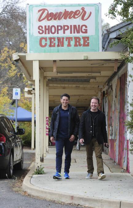 Developers of the Downer shops, Njegosh Popovich and Theo Poulos under the original shopping centre sign. Photo: Graham Tidy