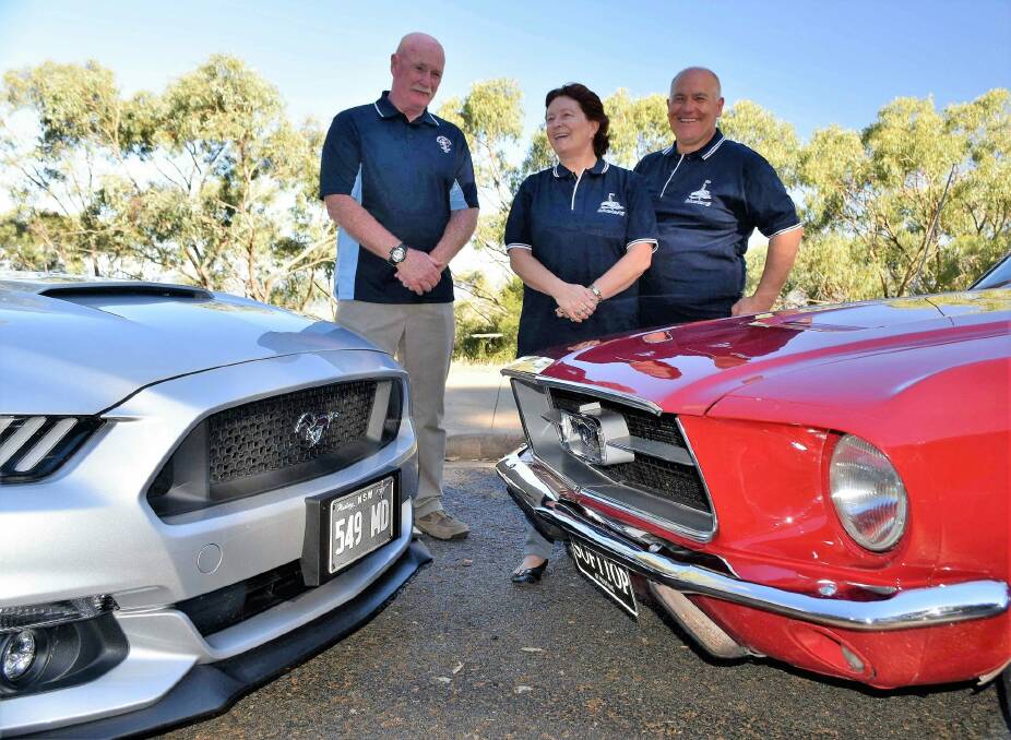 Canberra Mustang club members, from left, Mick Dainer, Sue Vilardi and Dominic Vilardi, with their cars. Photo: David Ellery
