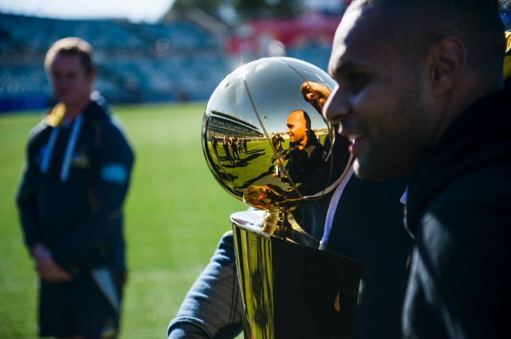 Patrick 'Patty' Mills visits the Brumbies at their training session at GIO Stadium ahead of their clash against the Chiefs.
Patrick Mills and Fotu Auelua reflected in the NBA trophy.
 Photo: Rohan Thomson