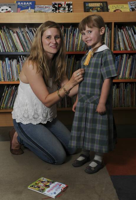 Raring to go: Penny Boyd helps her daughter, Helena, try on her new uniform. Photo: Graham Tidy