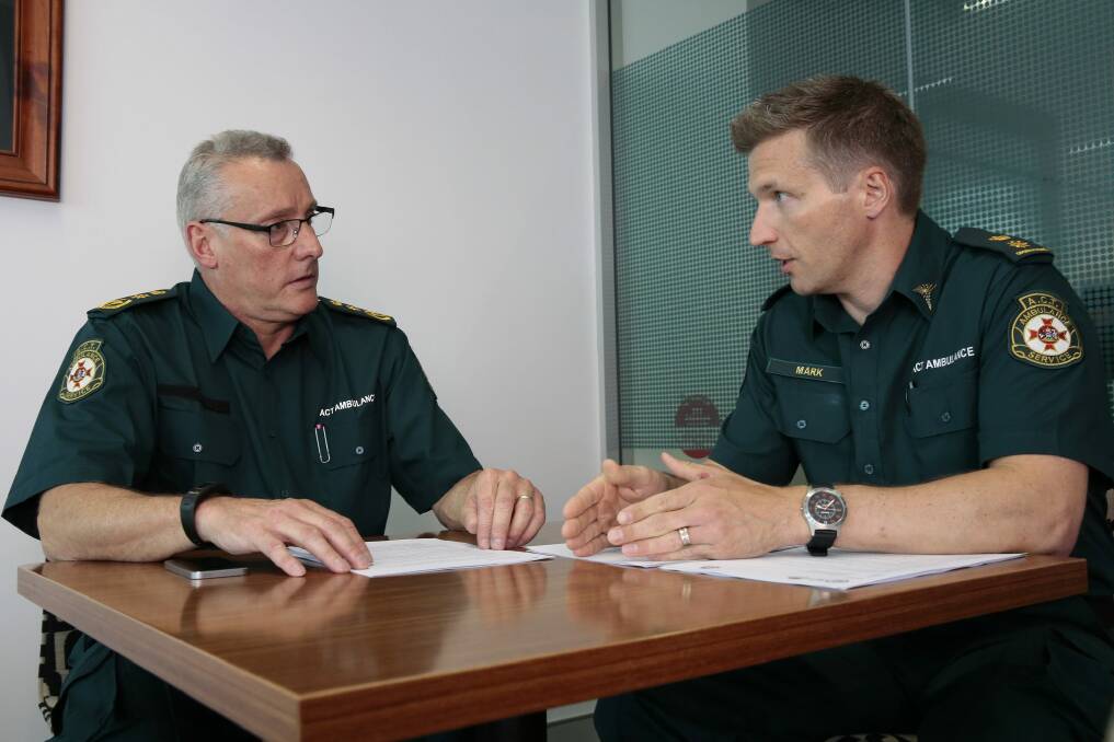 The acting chief officer of the ACT Ambulance Service, Jon Quiggin, left, attends a briefing on the extreme heat plan with capabilities planning operation manager Mark Molloy. Photo: Jeffery Chan