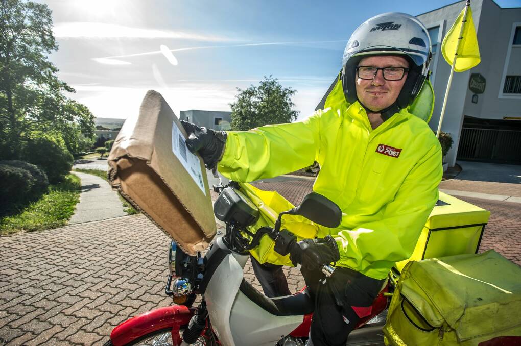 Australia Post postal delivery officer Daniel Mapstone has begun working earlier hours to deliver parcels when people are more likely to be at home to receive them.  Photo: Karleen Minney