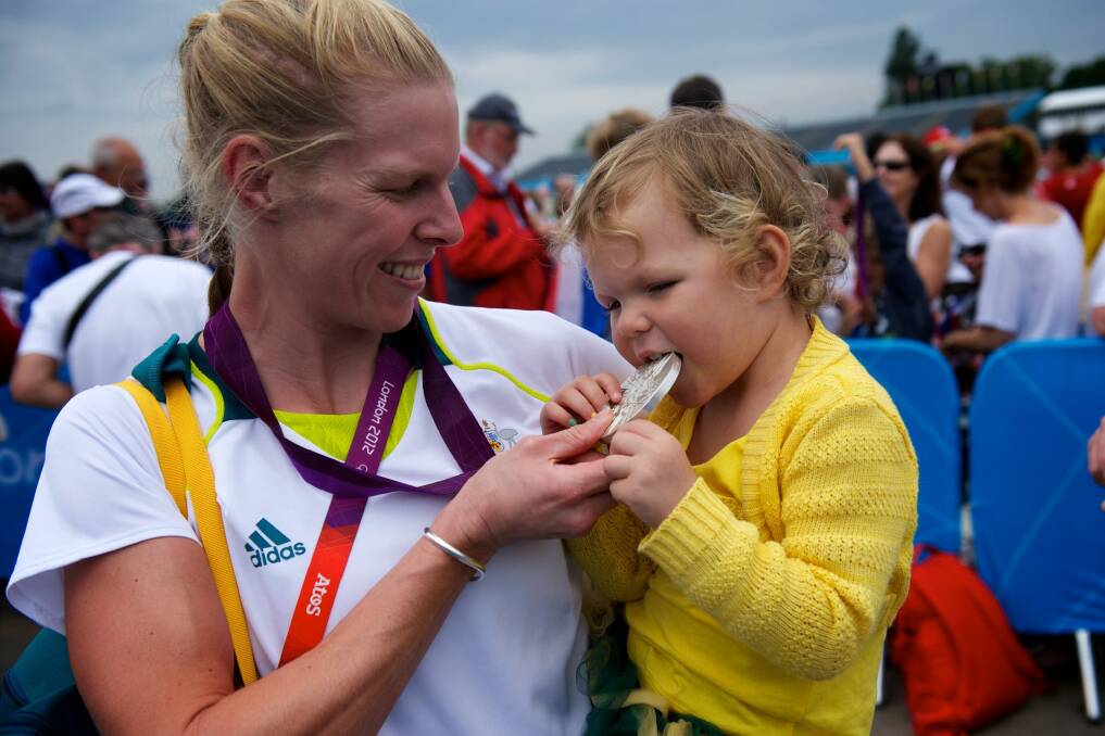 Sarah Tait shows off her medal to daughter Leila after winning silver at Eton Dorney. Photo: Jason South