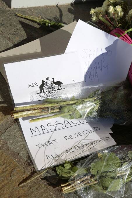 "Massacre": Protestors left handwritten notes with the flowers.  Photo: Jeffrey Chan 