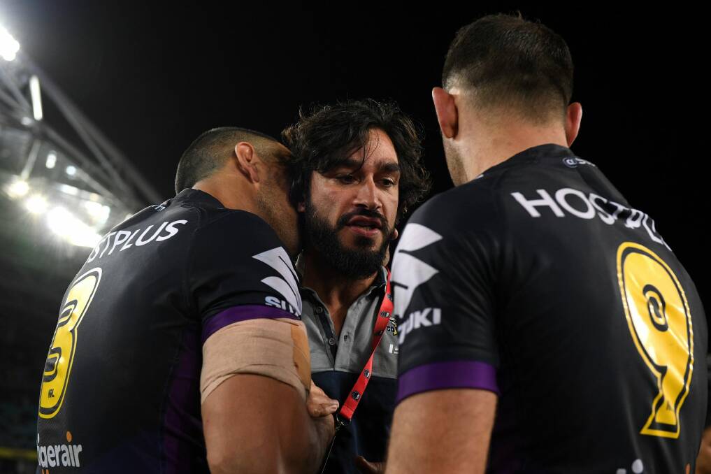 Injured Cowboy Johnathan Thurston congratulates Will Chambers (left) and Cameron Smith  after the Storm's grand final triumph. Photo: AAP