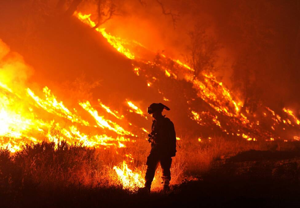 Firefighter Bo Santiago lights a backfire in California earlier this month.The fire has charred more than 60,000 acres and destroyed at least 24 residences. Photo: Josh Edelson/AP