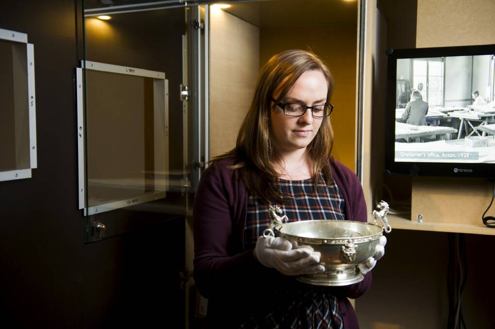 National Archives' Michelle Hughes, exhibitions coordinator, with a bowl that was presented to Stanley Melbourne Bruce at the launch of the Sydney in 1934.

  Photo: Rohan Thomson