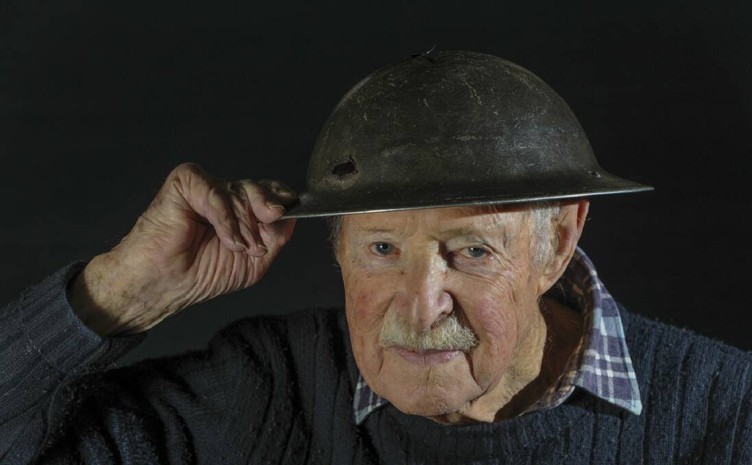 Joe Mullins, who turns 95 in July, with his helmet which was pierced by bullets during combat in 1945. Photo: Graham Tidy