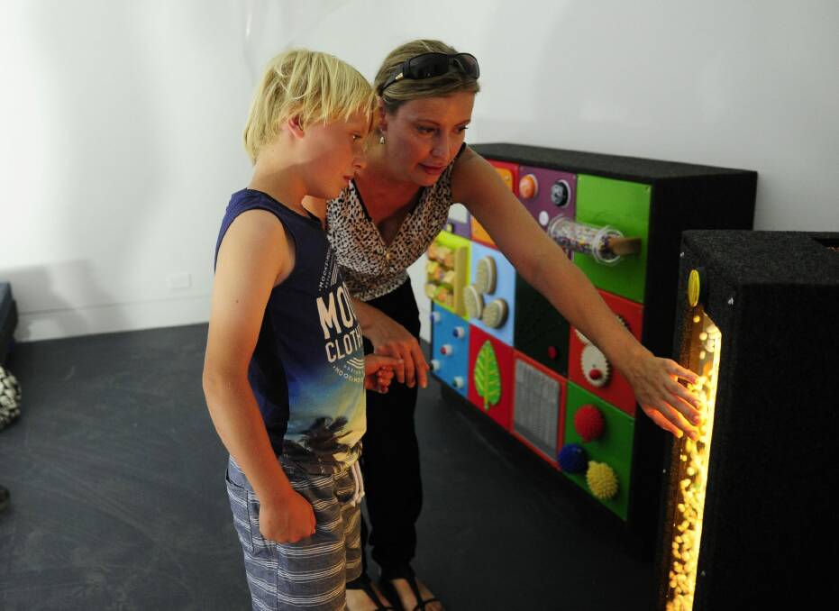 Kayne Lawton, 8, of Bruce, with his mother Beth in the sensory room at the Ricky Stuart House in Chifley. Photo: Melissa Adams 