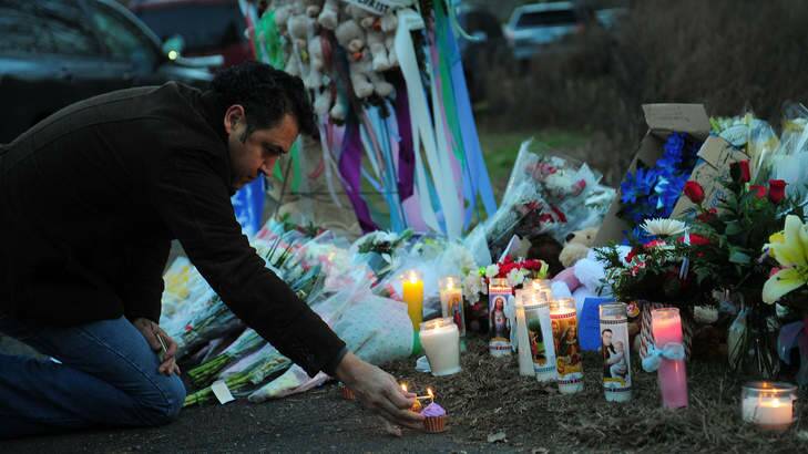 A man pays tribute to the victims of an elementary school shooting in Newtown, Connecticut on Saturday. Photo: AFP
