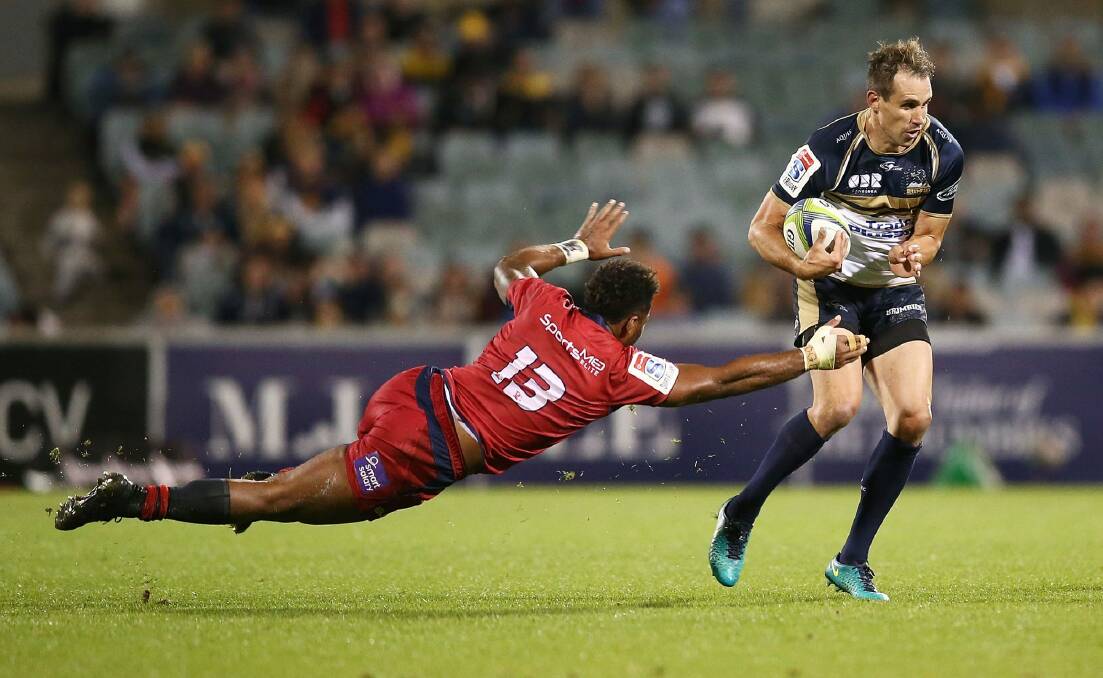 Andrew Smith of the Brumbies evades the tackle of Samu Kerevi of the Reds. Photo: Getty