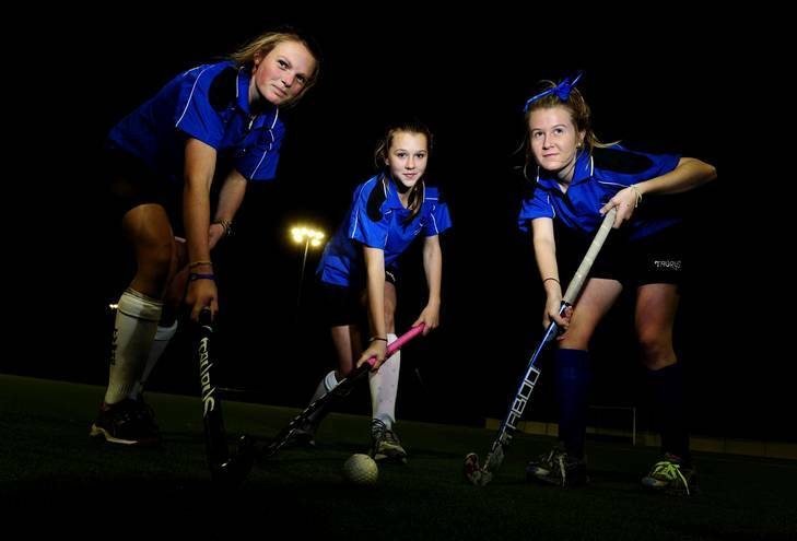 Tuggeranong Division One players Kristy Martens,14, Ellen Cornish,13, and Ellie Toole, 14, at the Tuggeranong Hockey grounds. Photo: Melissa Adams