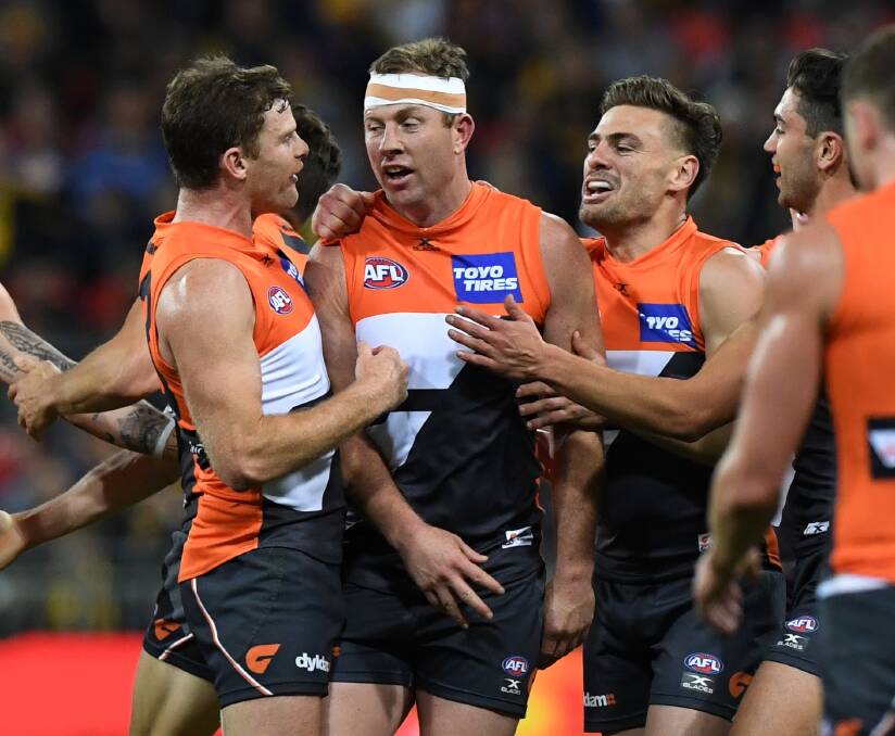 Steve Johnson celebrates with teammates after kicking one of his six goals. Photo: AAP