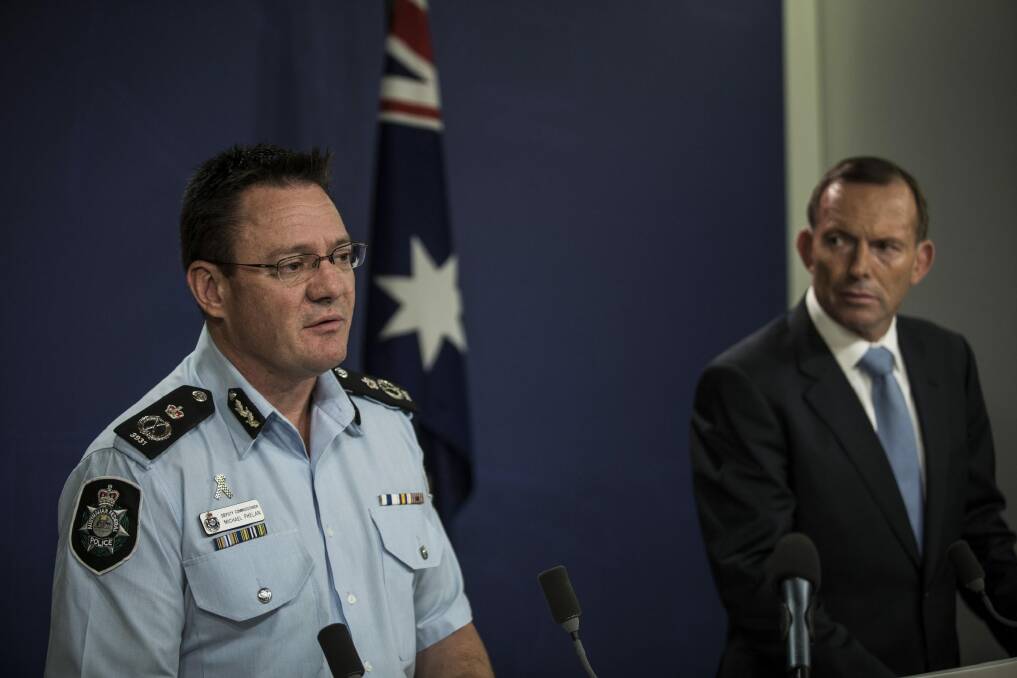 AFP Deputy Commissioner Michael Phelan and Prime Minister Tony Abbott speak in Sydney on Saturday. Photo: Dominic Lorrimer