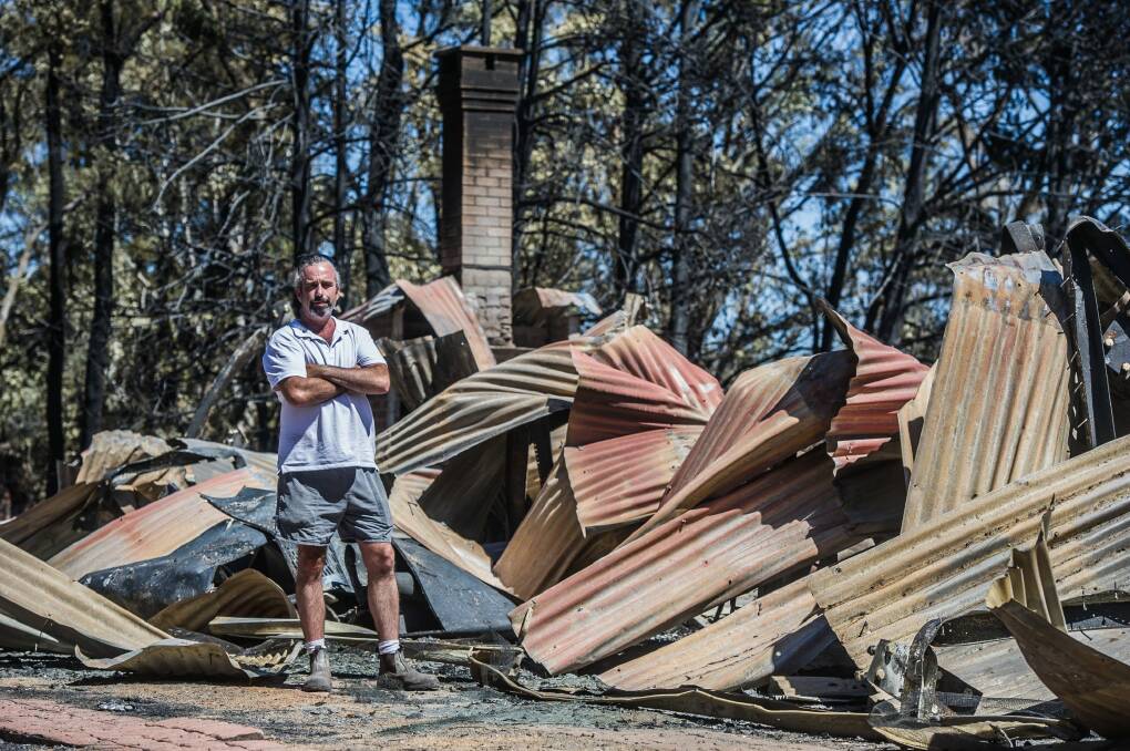 A home belonging to Richard Graham that lost in the Tarago fires. Farm-hand Scott Williams checks the damage. Photo: Karleen Minney