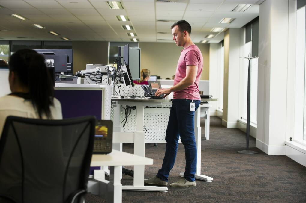 PwC consultant Tom Simmonds is one many office workers now embracing stand up desks for health benefits. Photo: Rohan Thomson