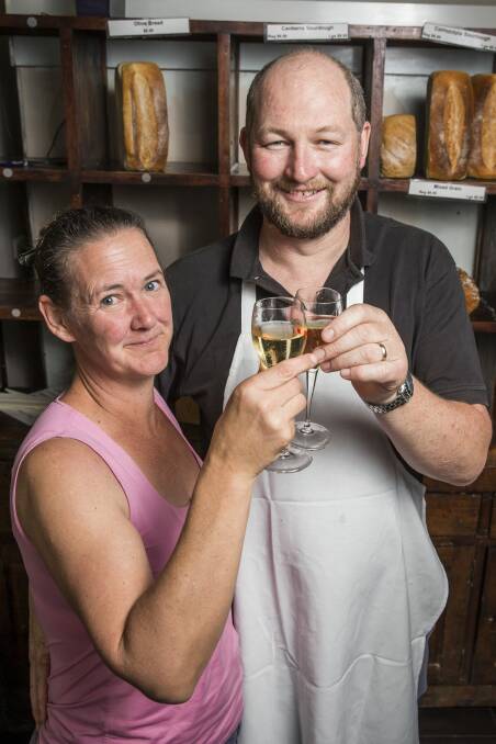 Paul Clowry and Trilby Rippon toast to the end of an era for the Cornucopia Bakery that shuts its doors on Christmas Eve after 30 years in Braddon. Photo: Matt Bedford
