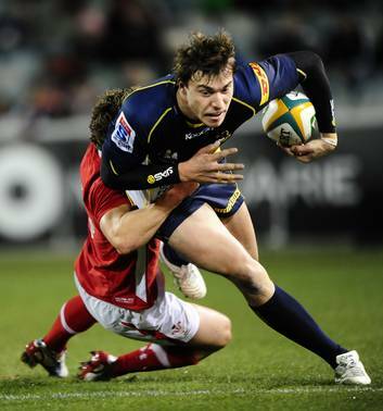 Brumbies player Cam Crawford is tackled by a Welsh defender. Photo: Melissa Adams