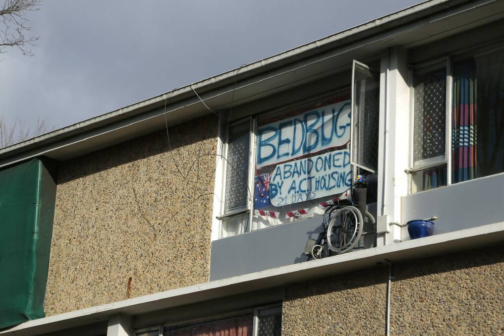 Protest sign in the window of the Northbourne Flats at Braddon. Photo: Jeffrey Chan